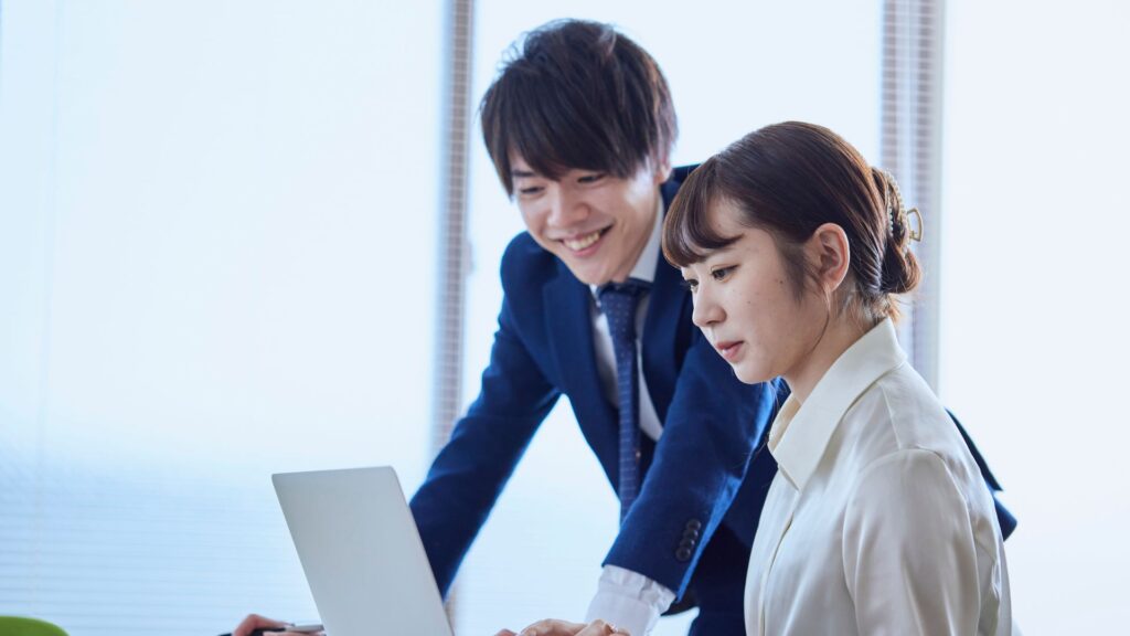 日本人メンバーがPCを見ながら仕事や役割を整理する様子